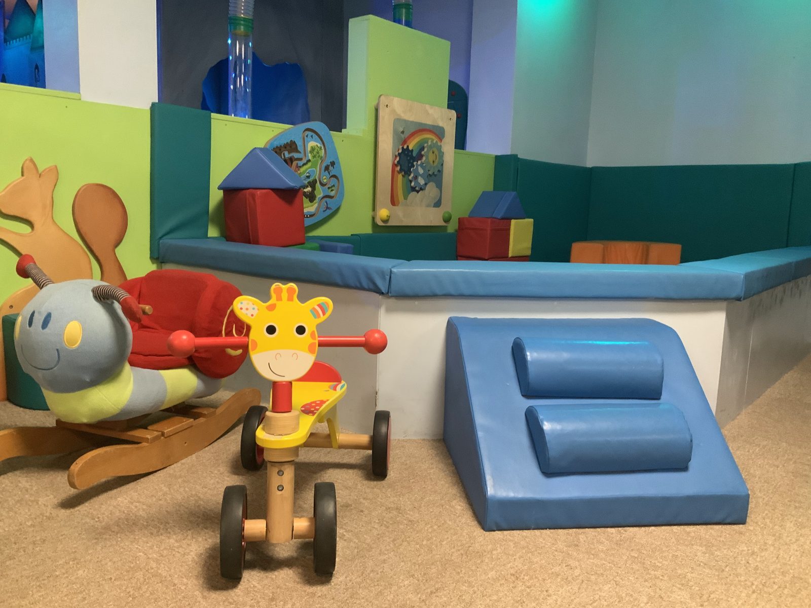 The toddler zone with ride-on toys and soft padded blocks